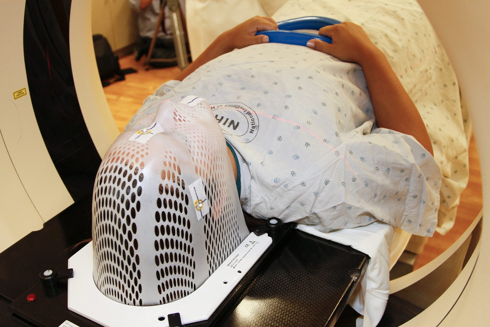 A person lying on the table of a computed tomography scanner, positioned inside the gantry
