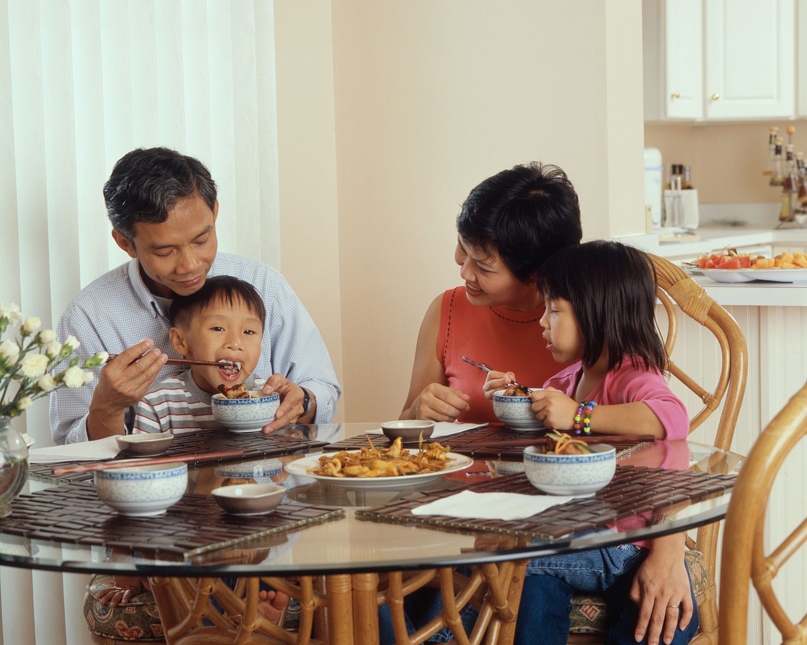 A family of four eating a meal together at a kitchen table