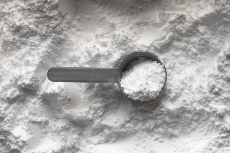 Macro shot of a creatine scoop full of white powder